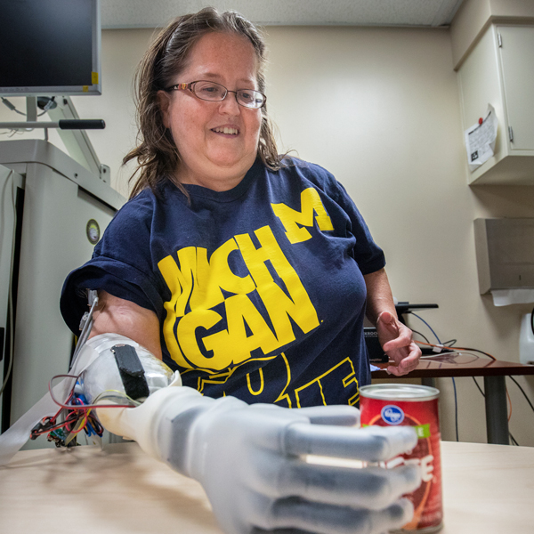 Woman grabs a can with prosthetic arm