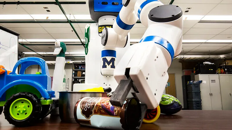 A Fetch robot uses its gripper to pick an object off a table of clutter