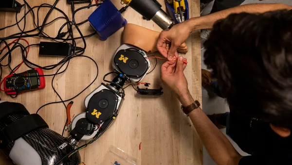 An open source leg on a table with wires and tools.
