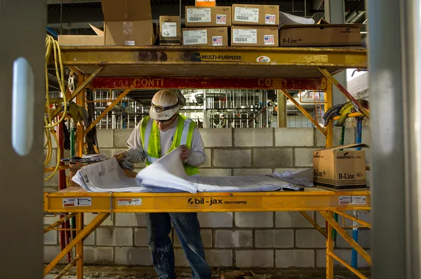 A construction worker reads plans.