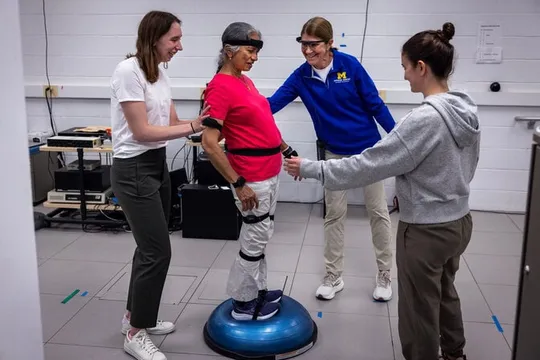 Geeta Peethambaran stands on a balance trainer, testing steadiness on a difficult exercise.