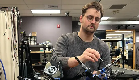 Thomas E Augenstein working with the Hand eMBot, his self-powered robot to improve post-stroke hand function.