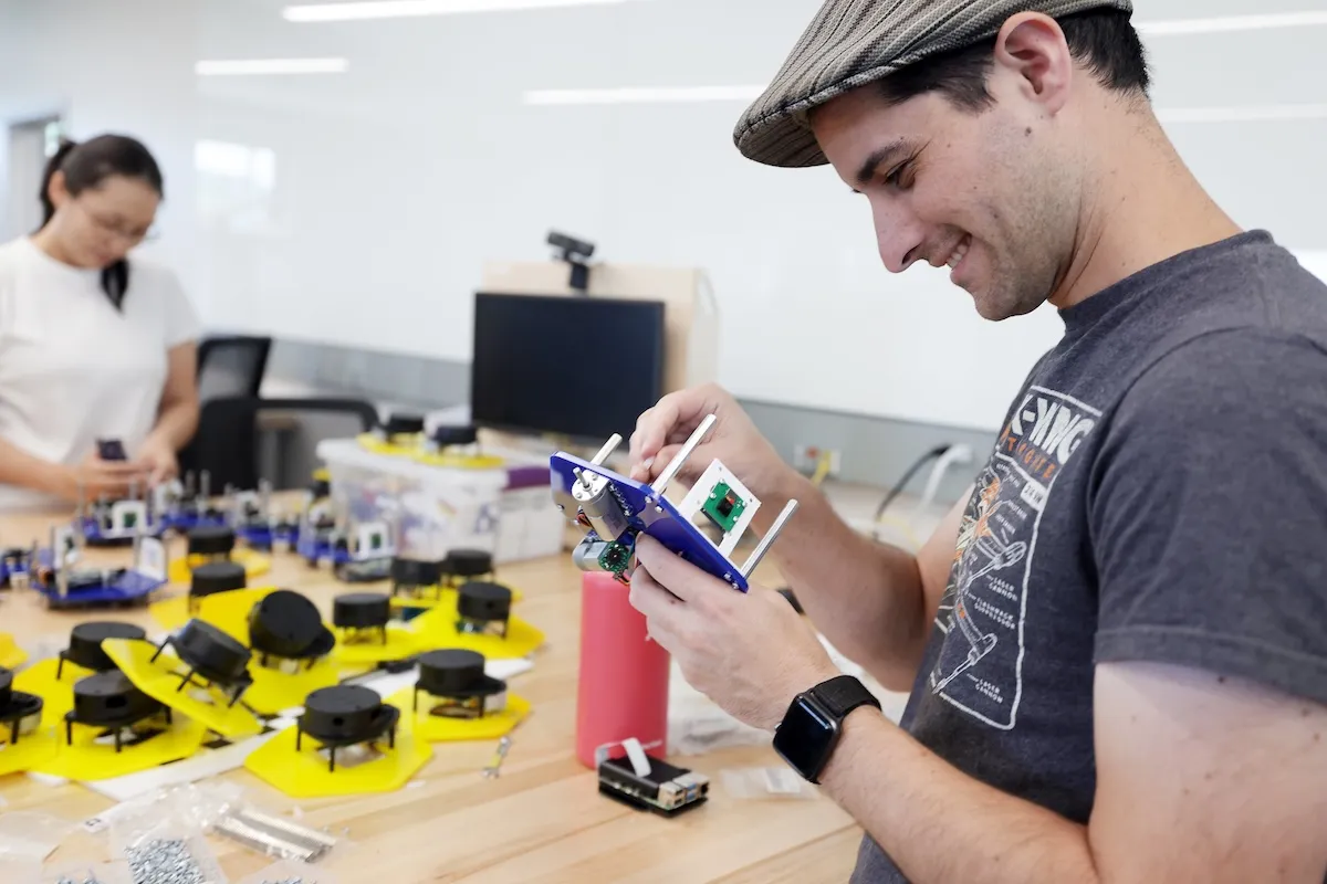 Graduate students help assemble classroom robots for an upcoming semester