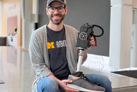 Ross Cortino holds up a robotic prosthetic leg.