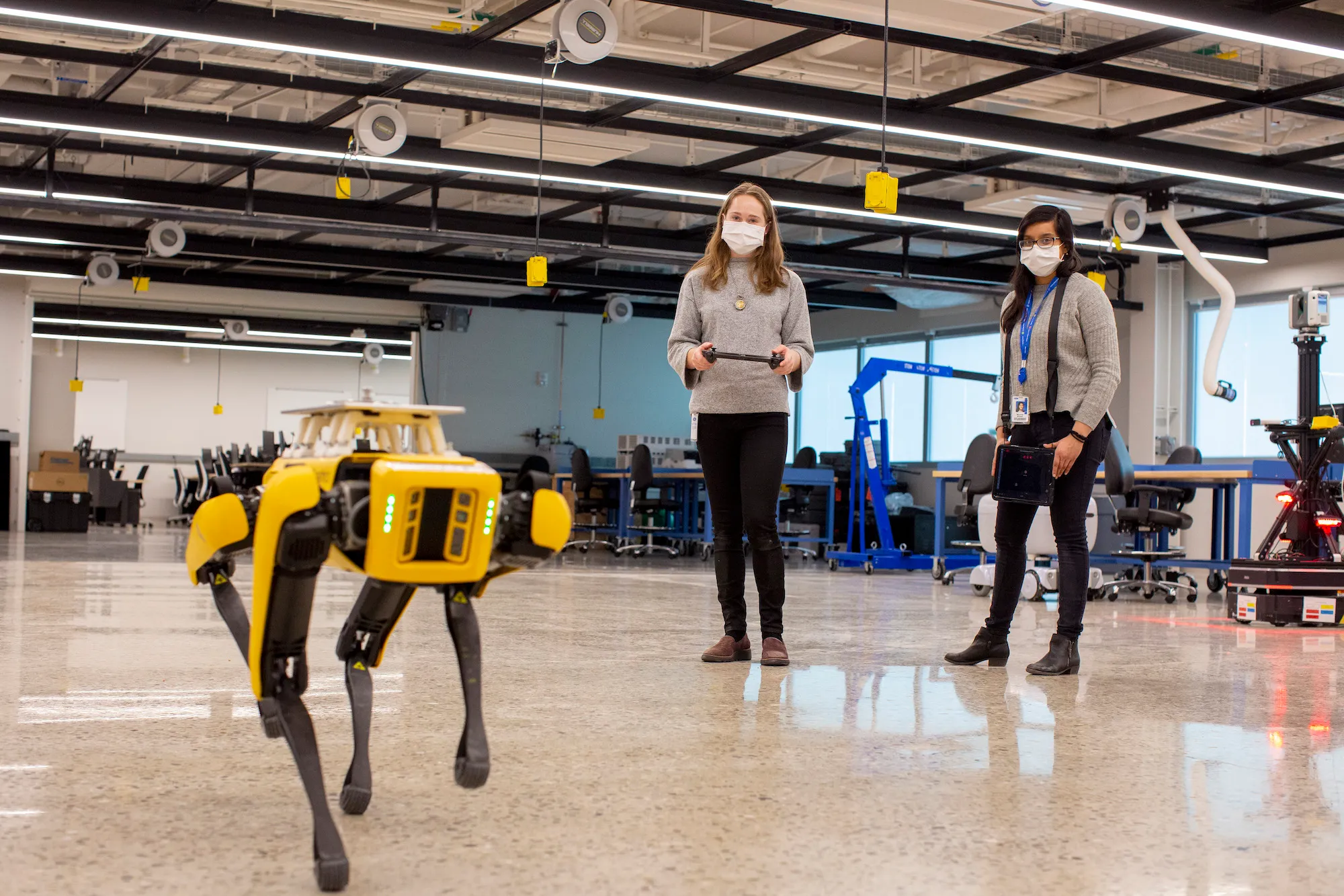 Researchers remotely control a Spot robot in a lab.