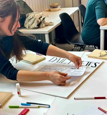 A retreat participant assembles the front page of a newspaper in the future.