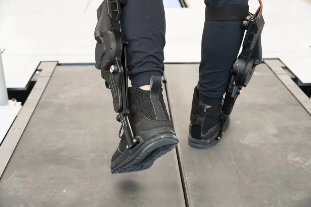 Leo Medrano, a PhD student in the Neurobionics Lab at the University of Michigan, tests out an ankle exoskeleton on a two-track treadmill.