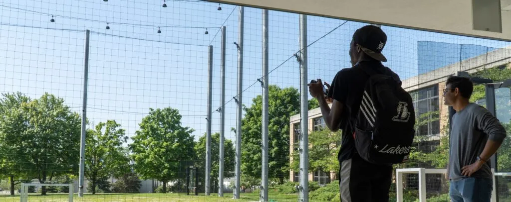 Hardik Parwana gives drone flight lessons to a visiting high school student outside at M-Air.