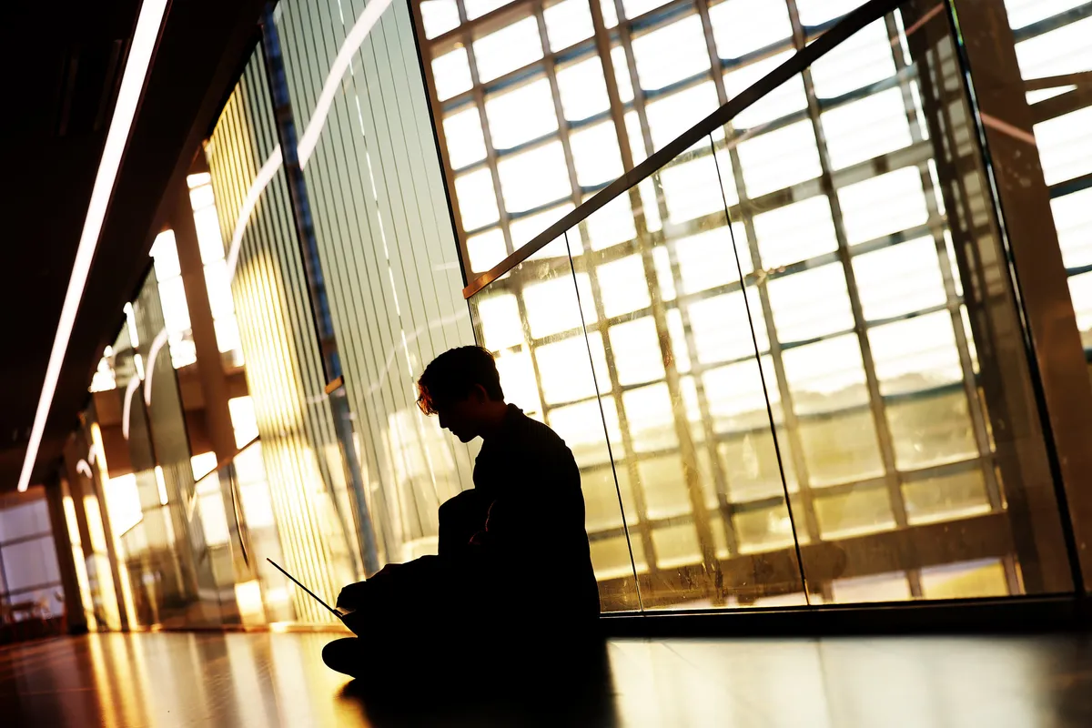 A silhouette of a student working in the Robotics Building