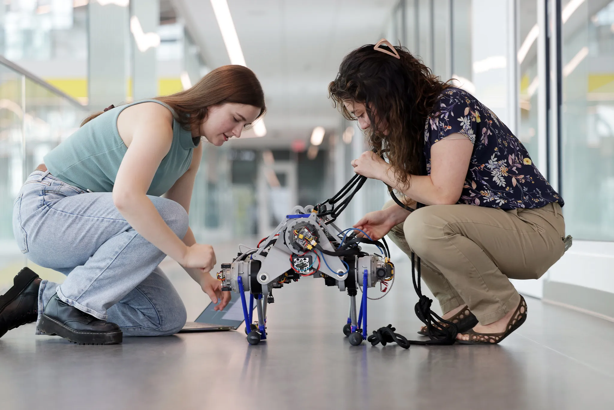 A graduate student works on a quadruped robot