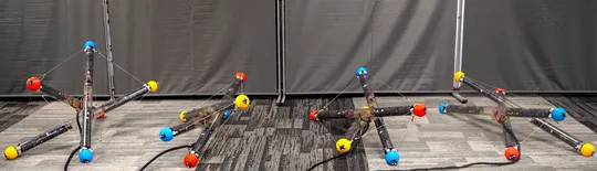 A robot made of three tubes and cables connecting them tumbles across the floor in different arrangements in this composite image.