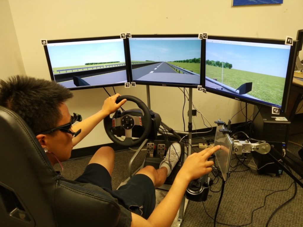 Study participant behind screens driving a virtual car