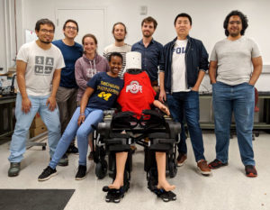Eva Mungai visits Ayonga Hereid, professor of mechanical and aerospace engineering at Ohio State University and former post-doc at U-M, and the Cyberbotics Lab, with Wandercraft’s Atlante exoskeleton in sitting position. Photo courtesy Cyberbotics Lab.